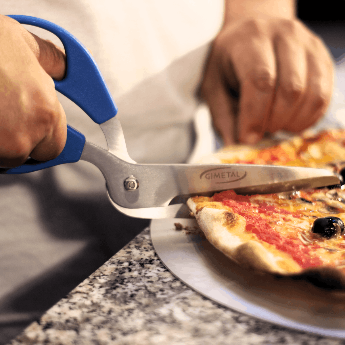 Profi Pizzaschere GiMetal beim Schneiden einer Pizza AC-FR
