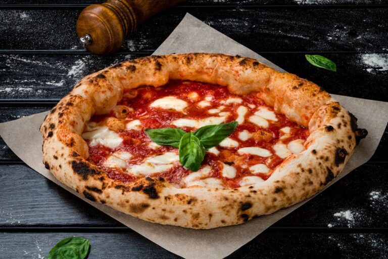 Pizza im neapolitanischen Stil mit hohem, luftigem Rand, Mozzarella und Basilikum
