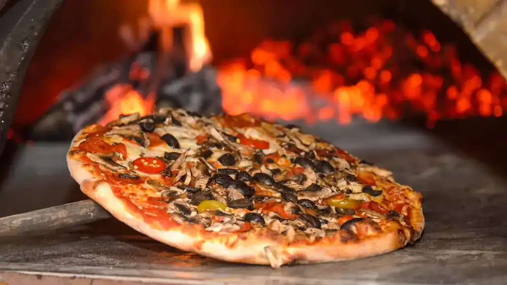 Pizza auf dem Backstein im heißen Steinofen